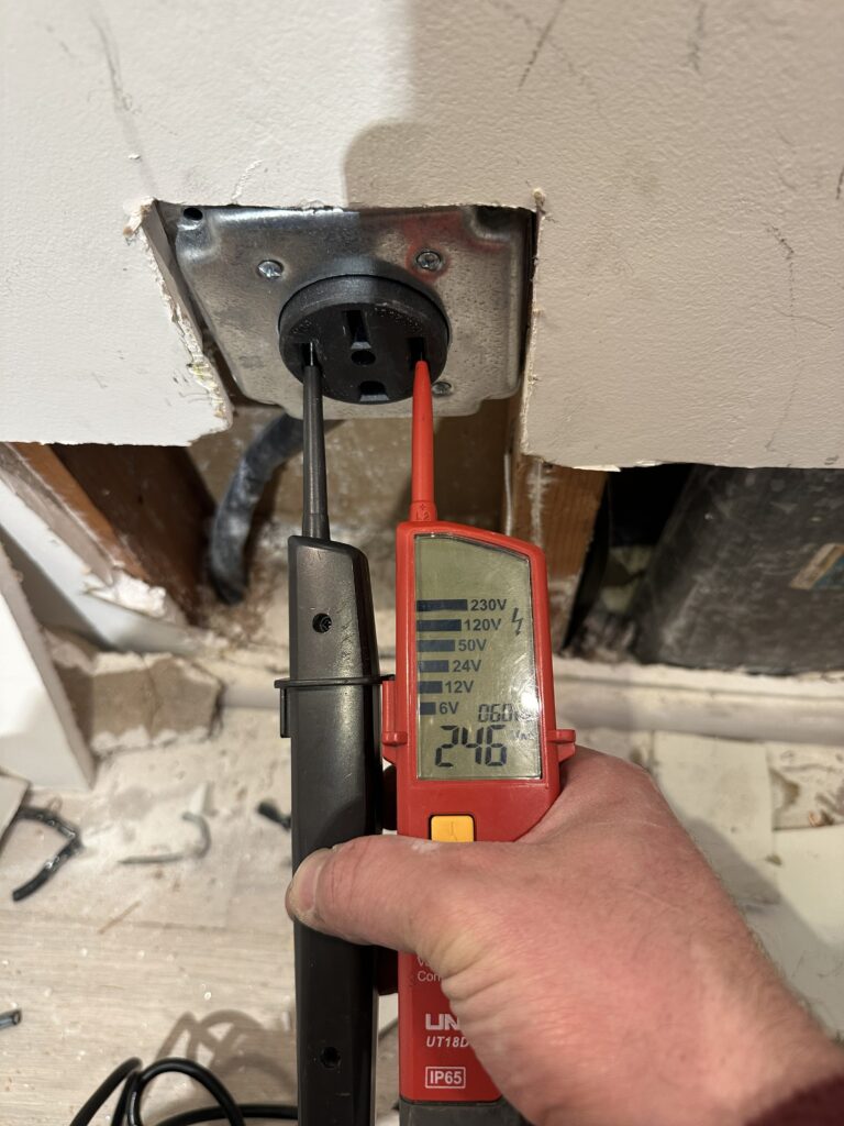 Electrician testing voltage at an electrical outlet during troubleshooting in San Bruno, CA