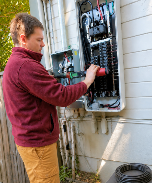 Electrician working on an open residential electrical panel in San Mateo, CA